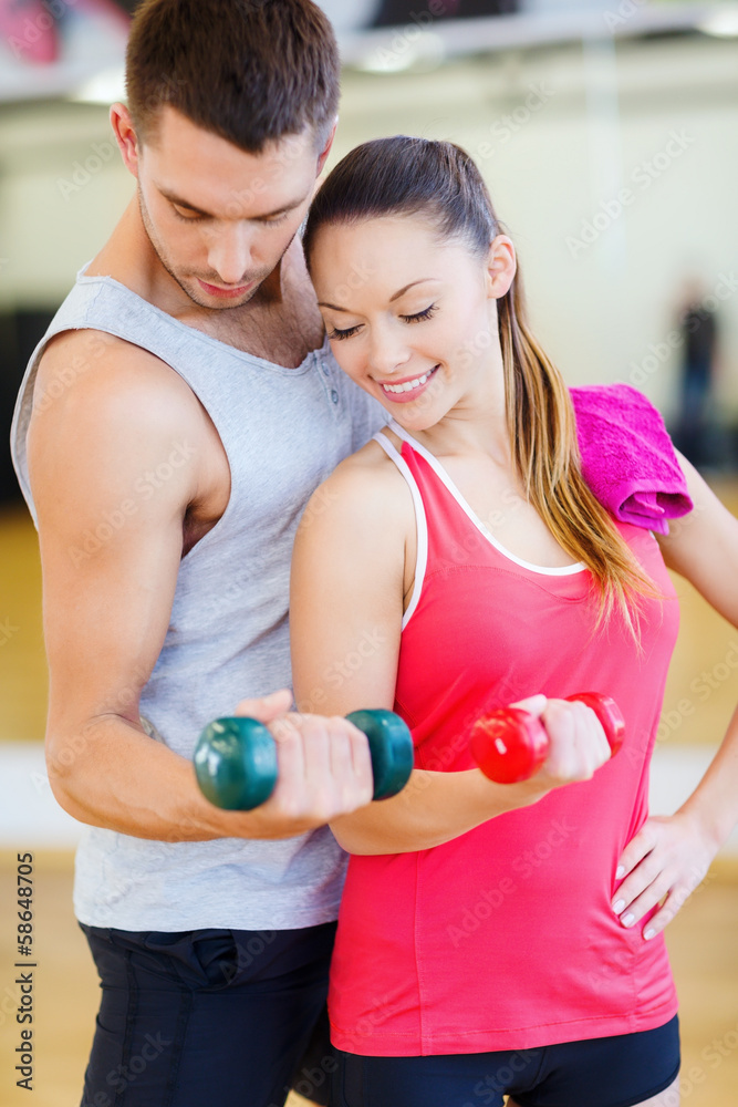 two smiling people working out with dumbbells two smiling people working out with dumbbells