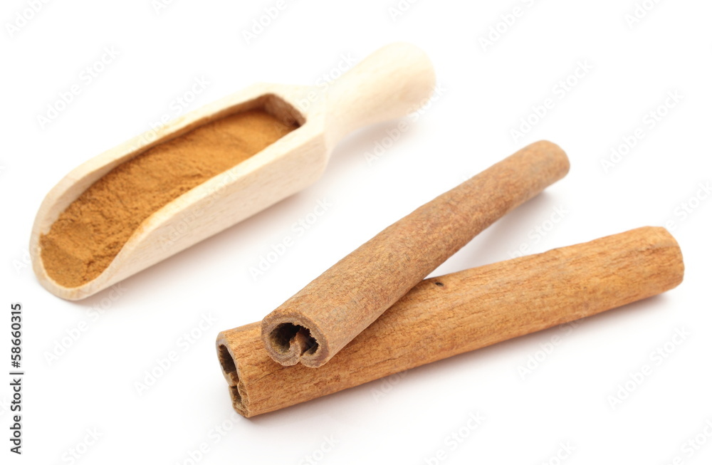 Powdery and stack of cinnamon sticks on white background Powdery and stack of cinnamon sticks on white background