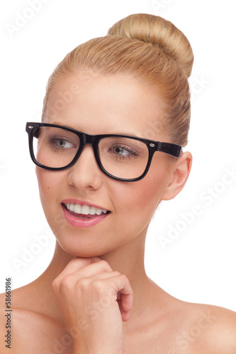 Beautiful young girl in glasses smiling and looking away.