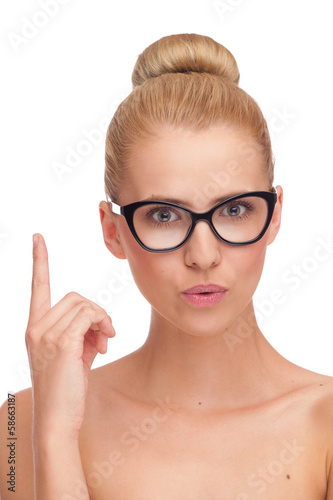 Young woman in black glasses pointing up.