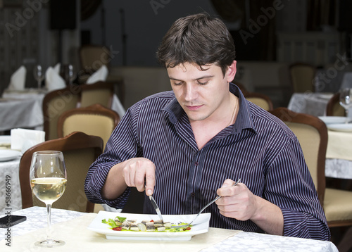 young man having dinner in a restaurant