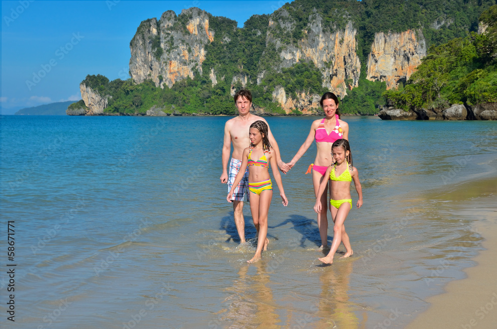 Happy family on tropical beach having fun on vacation Happy family on tropical beach having fun on vacation