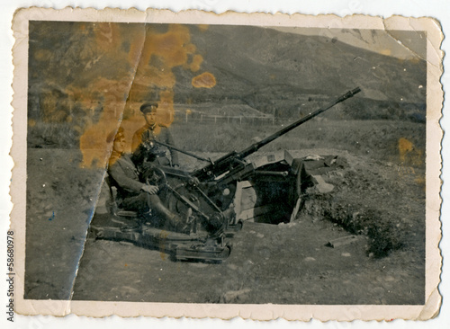 CIRCA 1960: Two soldiers serving antiaircraft gun photo