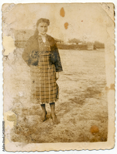 CIRCA 1935: Older woman stands in a field