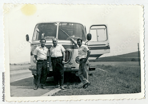 Slika na platnu CIRCA 1960: Men standing in front of the bus, on the road
