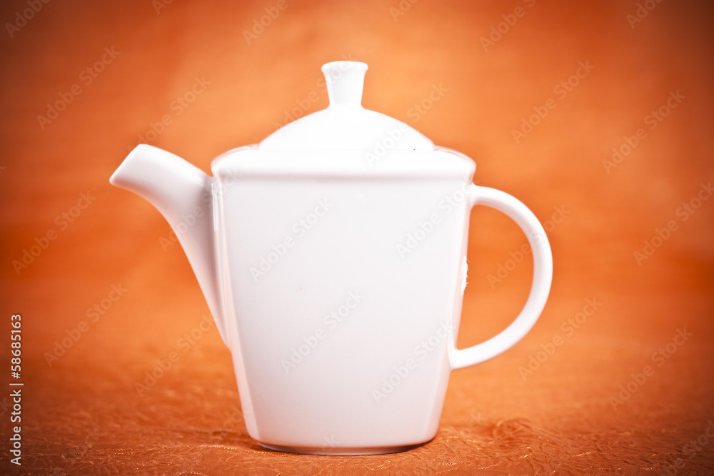 teapot isolated on orange fabric background teapot isolated on orange fabric background