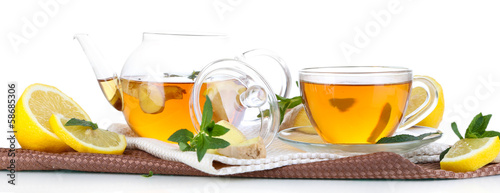 Kettle and cup of tea with ginger on napkin isolated on white