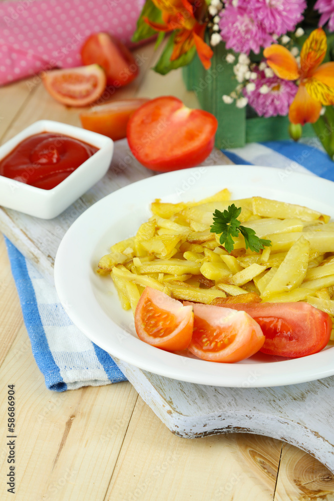 Ruddy fried potatoes on plate on wooden table close-up