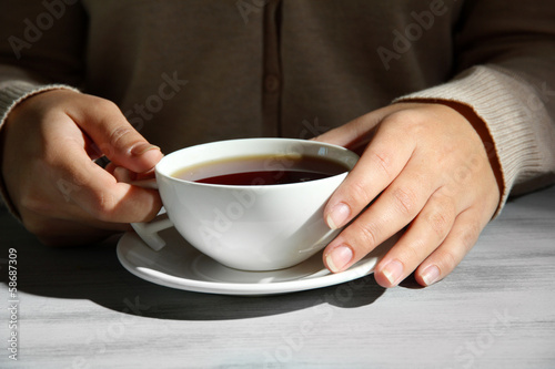 Hands holding mug of hot drink, close-up