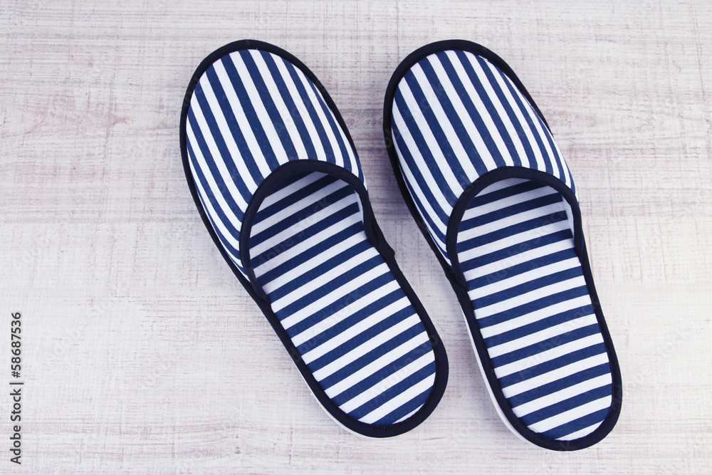 Striped slippers on wooden background Striped slippers on wooden background
