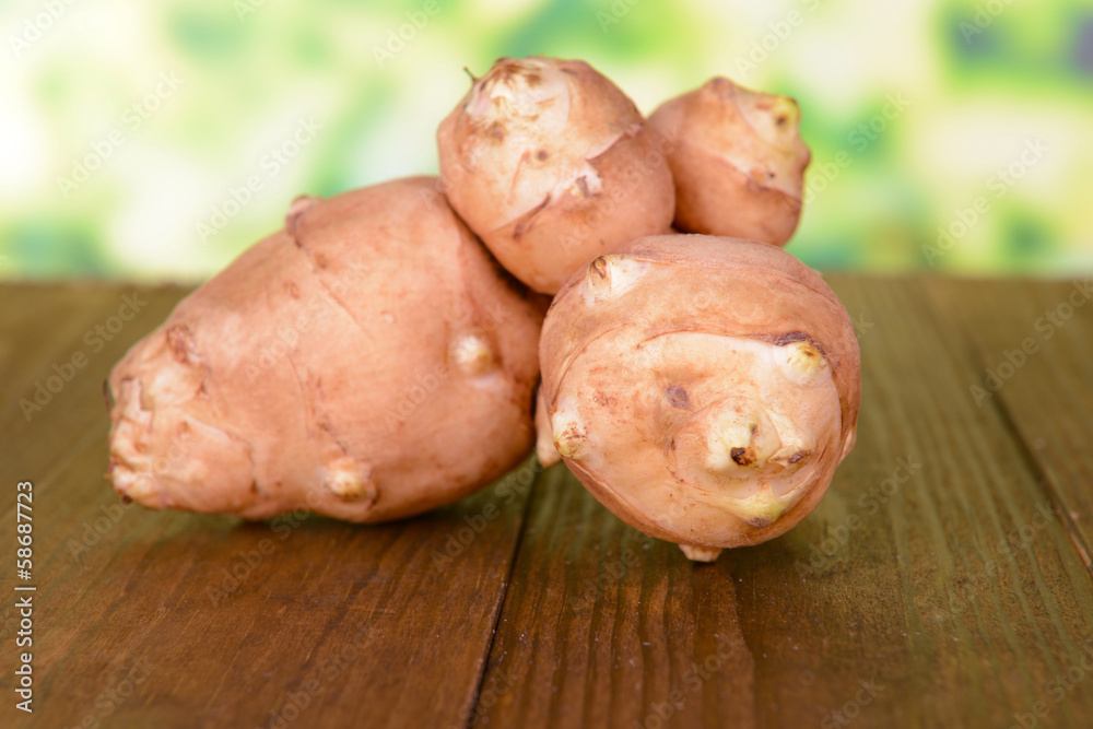 Topinambur roots on table on bright background Topinambur roots on table on bright background