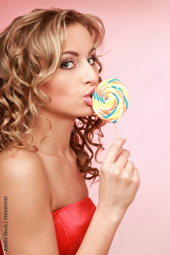 young happy woman with lollipop, isolated on pink background.