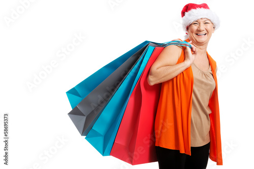 An old woman holding presents/bags in santa hat.