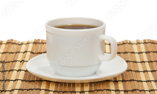 Cup of coffee and saucer on a bamboo napkin