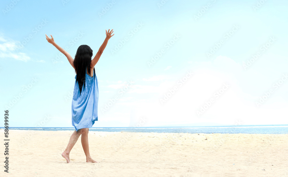 Girl at the beach raised her hands up