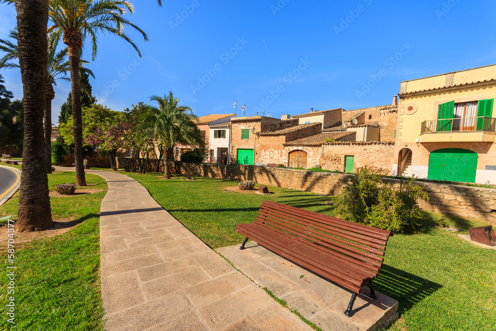 Bench alley in a park spring blooming trees, Alcudia, Majorca