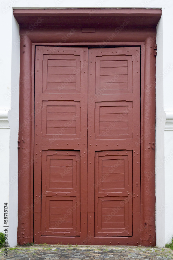 Red entrance door in front of residential house