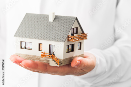 miniature house on hand, white background
