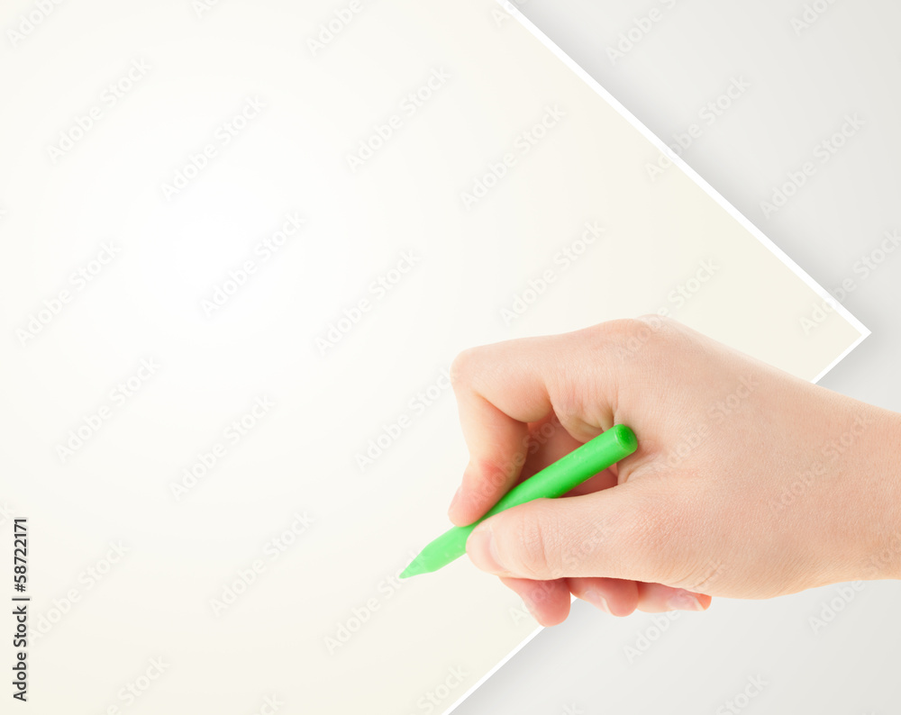 Child drawing with colorful crayon on empty blank paper