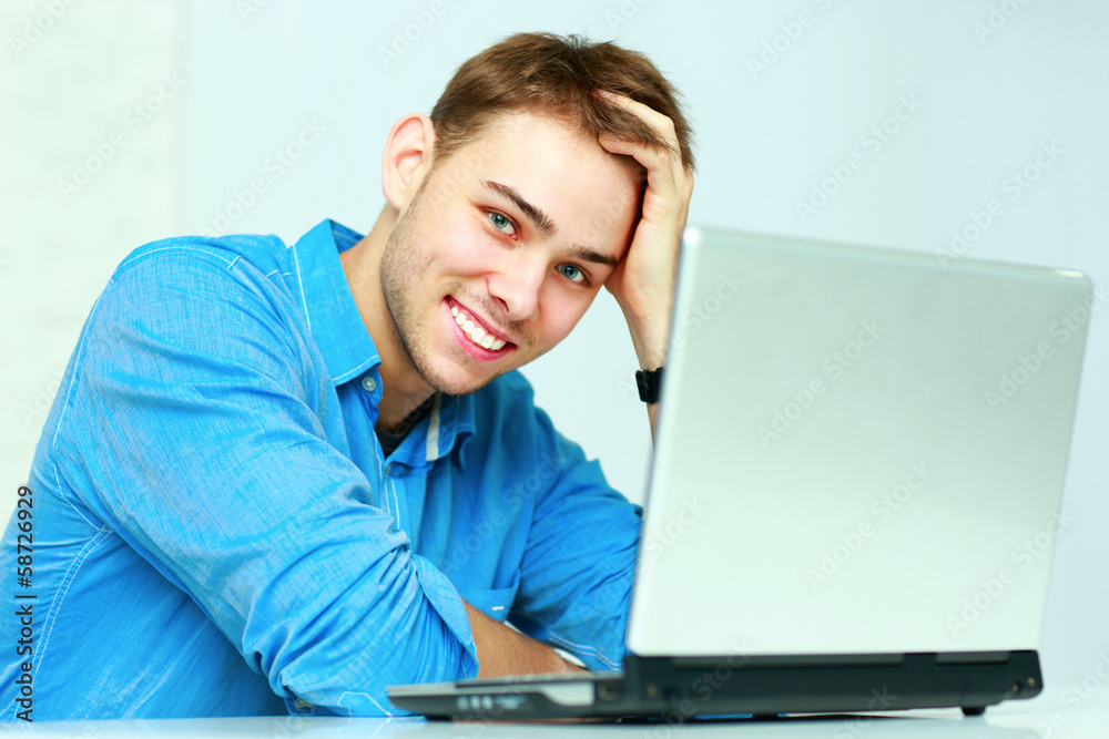 Young cheerful businessman sitting at the table Young cheerful businessman sitting at the table