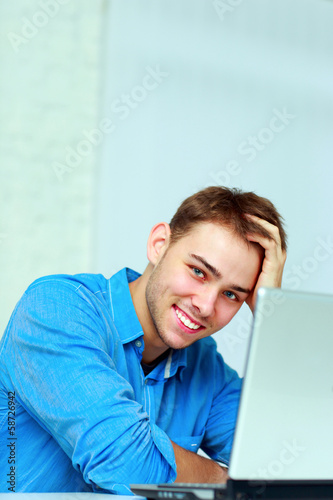 Young happy businessman sitting at the table 