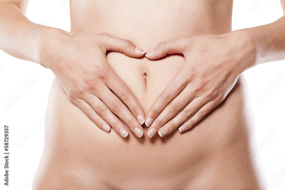 woman make heart shape with her fingers on her abdomen