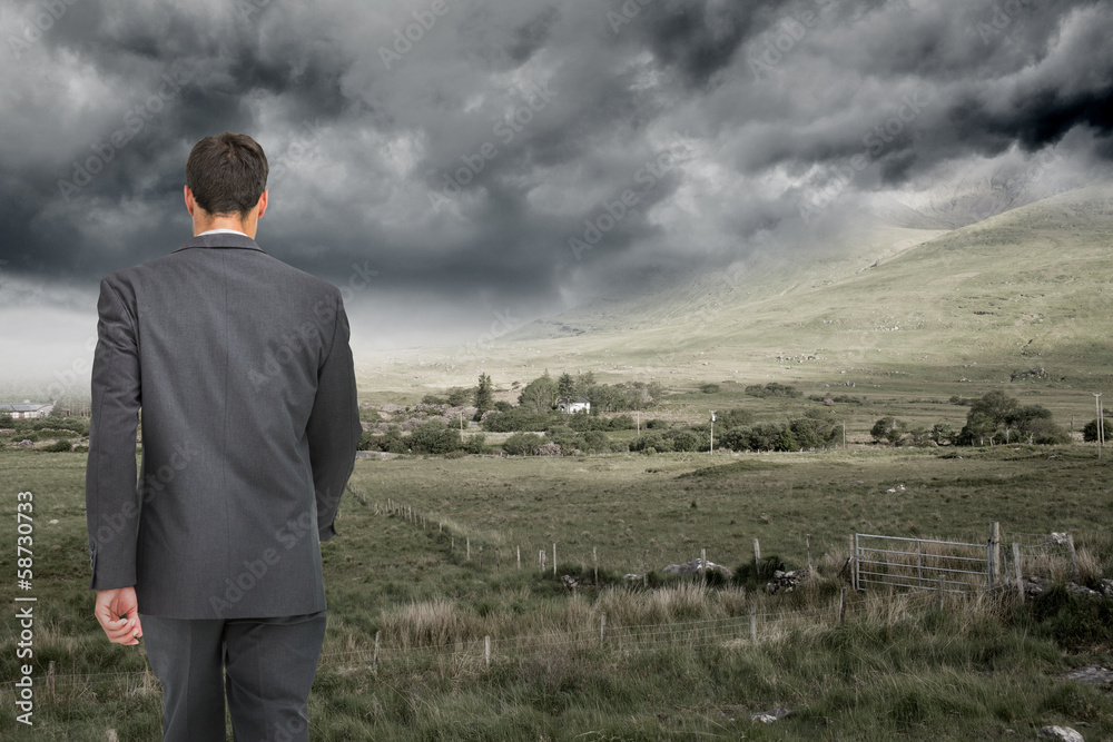 Composite image of young businessman walking away from camera Composite image of young businessman walking away from camera