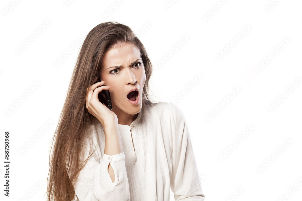 shocked young woman getting bad news on the phone shocked young woman getting bad news on the phone