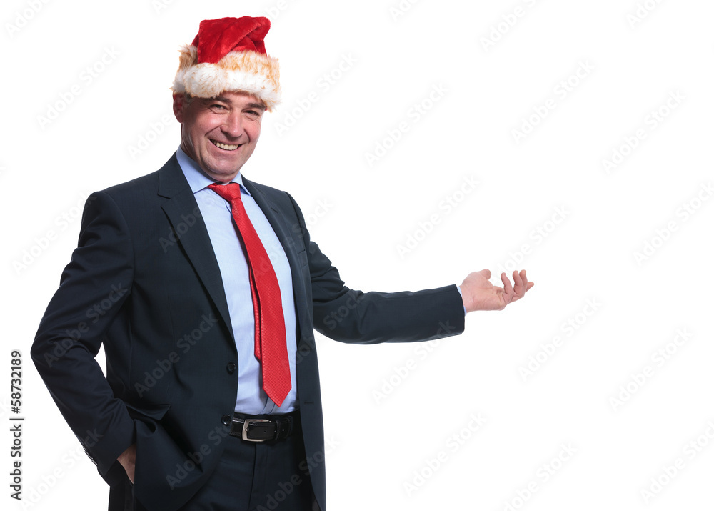 smiling mature business man in santa claus hat presenting smiling mature business man in santa claus hat presenting