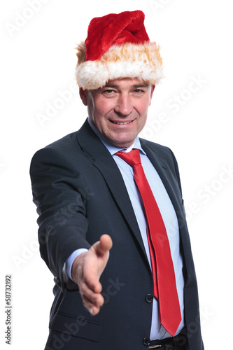 business man in christmas hat welcomes you with a hand shake