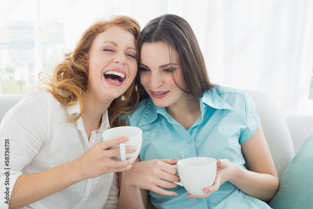 Friends with coffee cups enjoying a conversation at home Friends with coffee cups enjoying a conversation at home