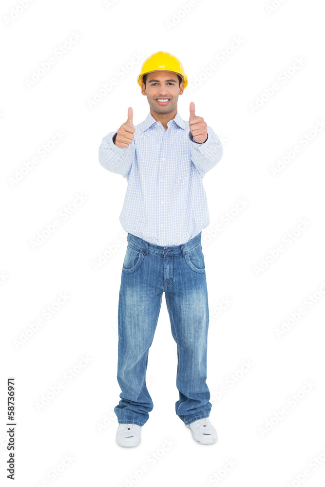 Smiling handyman in yellow hard hat gesturing thumbs up Smiling handyman in yellow hard hat gesturing thumbs up