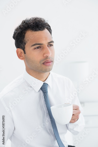Serious well dressed man drinking coffee