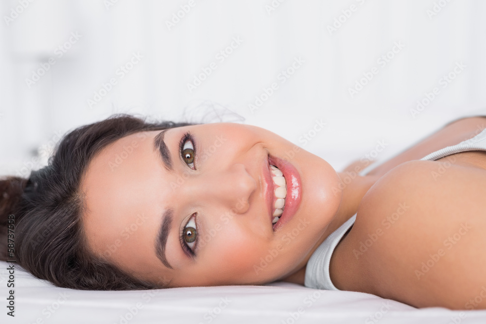 Smiling pretty young woman relaxing in bed Smiling pretty young woman relaxing in bed