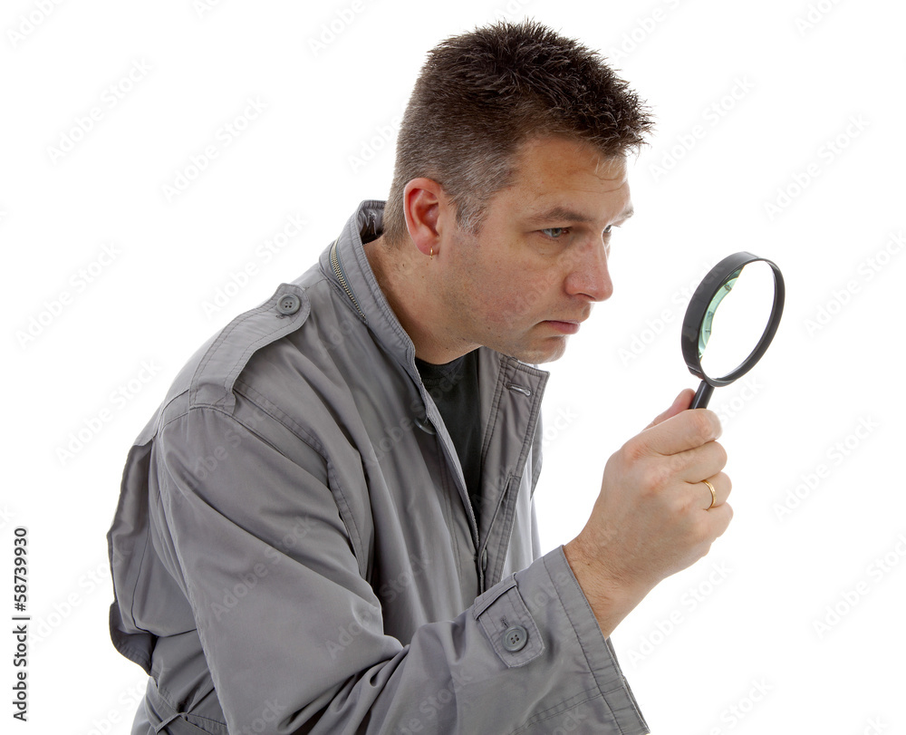 Man with raincoat is looking with magnifying glass over white ba Man with raincoat is looking with magnifying glass over white ba