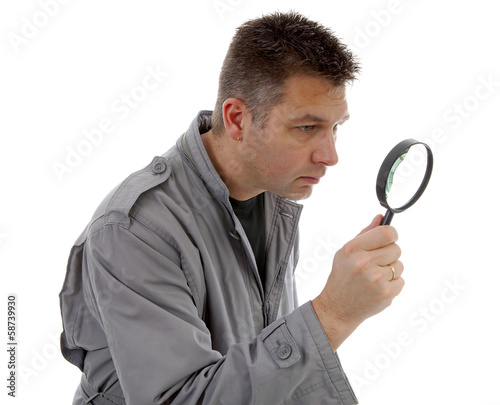 Man with raincoat is looking with magnifying glass over white ba