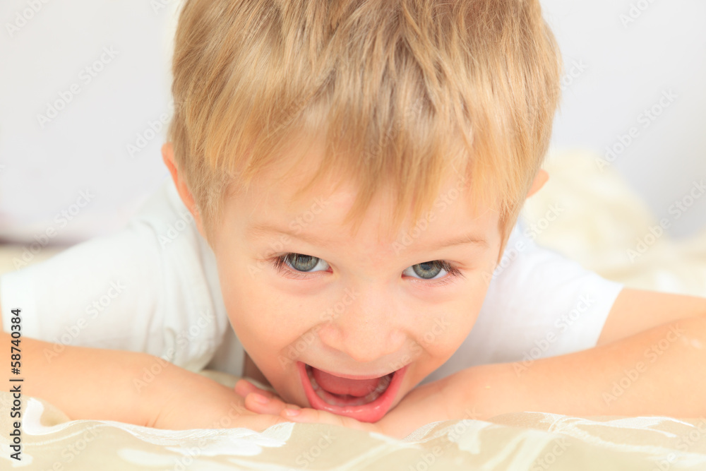 portrait of happy little boy lying in bed portrait of happy little boy lying in bed