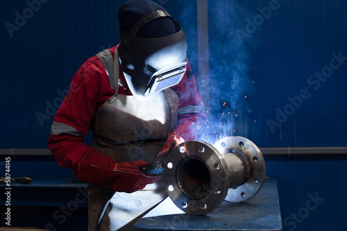 Welder with protective mask welding metal and sparks