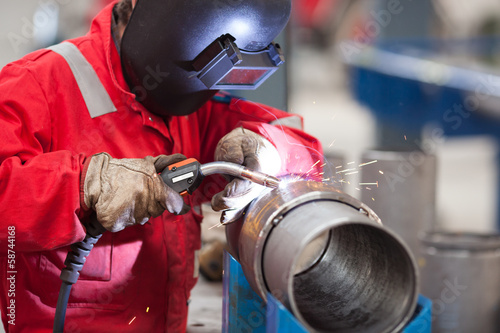 Welder with protective mask welding metal and sparks