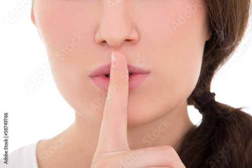close up of young woman with finger on lips isolated on white