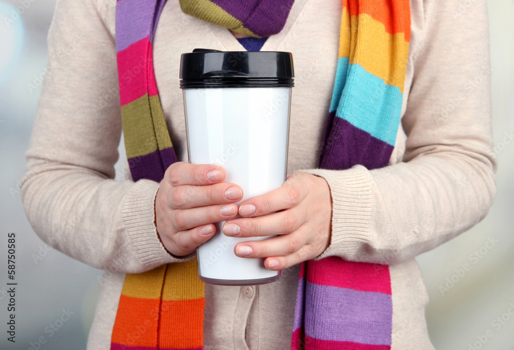 Hot drink in plastic glass in hands on bright background Hot drink in plastic glass in hands on bright background