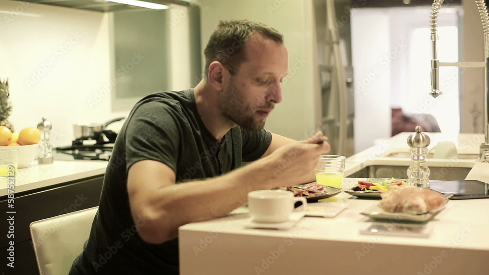 Young man eating meal in the kitchen Young man eating meal in the kitchen