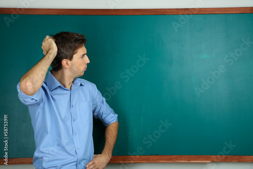 Young teacher near chalkboa...