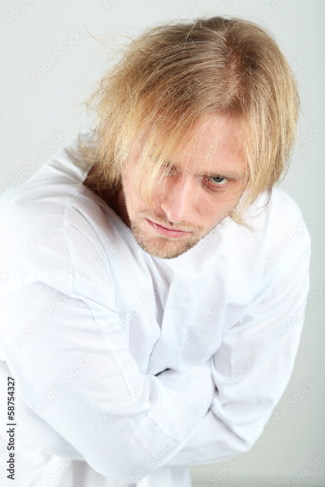 Mentally ill man in strait-jacket on gray background Mentally ill man in strait-jacket on gray background
