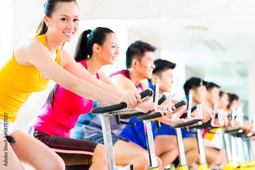 Asian people in spinning bike training at fitness gym