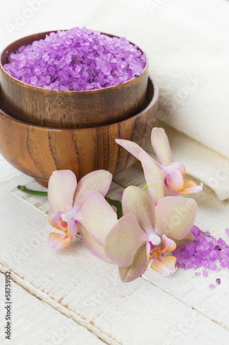 Spa concept. Flowers, sea salt  and towel on white wooden backgr photo