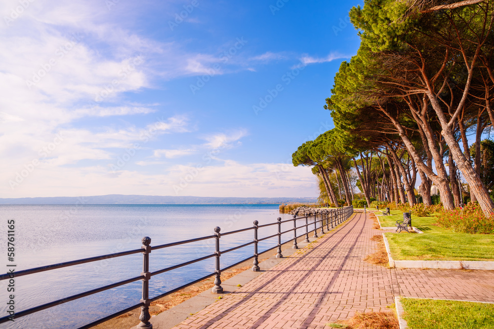 Promenade and pine trees in Bolsena lake, Italy. - obrazy, fototapety, plakaty 