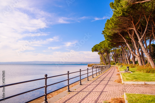 Promenade and pine trees in Bolsena lake, Italy.