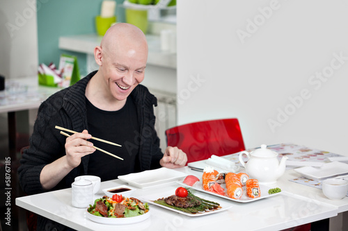 Man eats sushi.