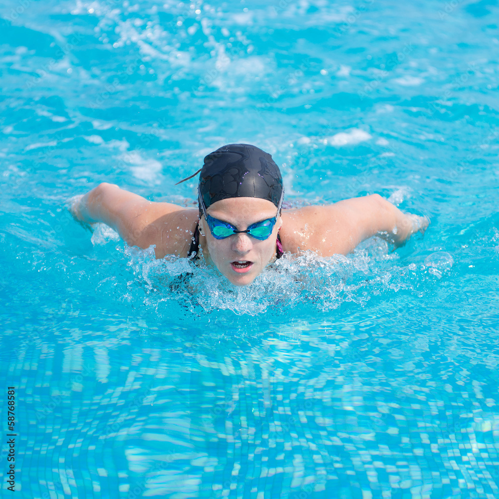 Young girl swimming butterfly stroke style